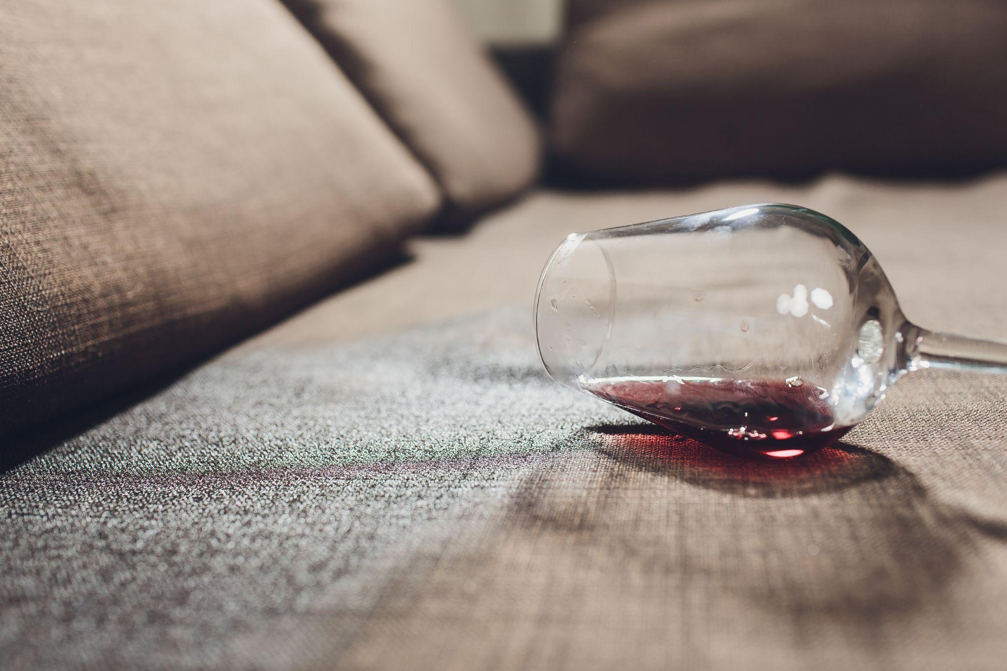 Red wine spilled on a grey couch sofa